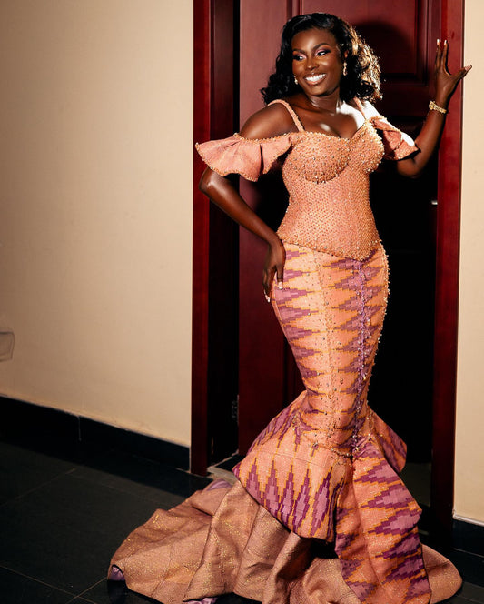kente designs dresses Our #QAWoman @msafriyie wears this kente mermaid-style gown with intricate patterns and beadwork. It features a blend of gold and peach tones, a sweetheart neckline, and an asymmetrical design that